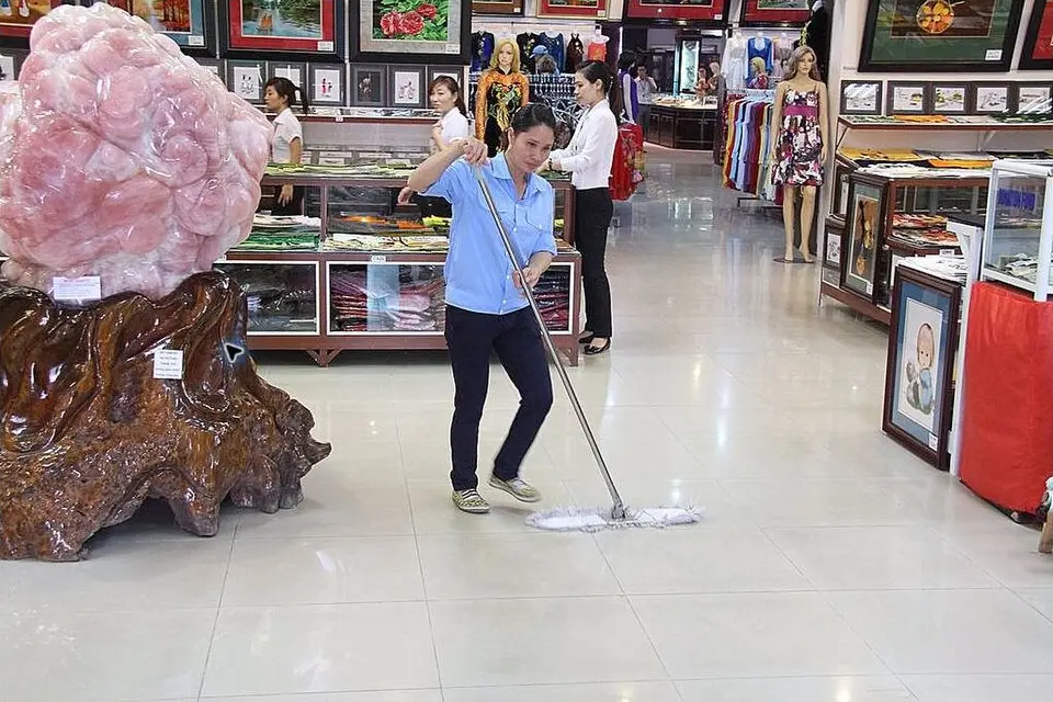 Profissional limpando o piso de um espaço comercial
